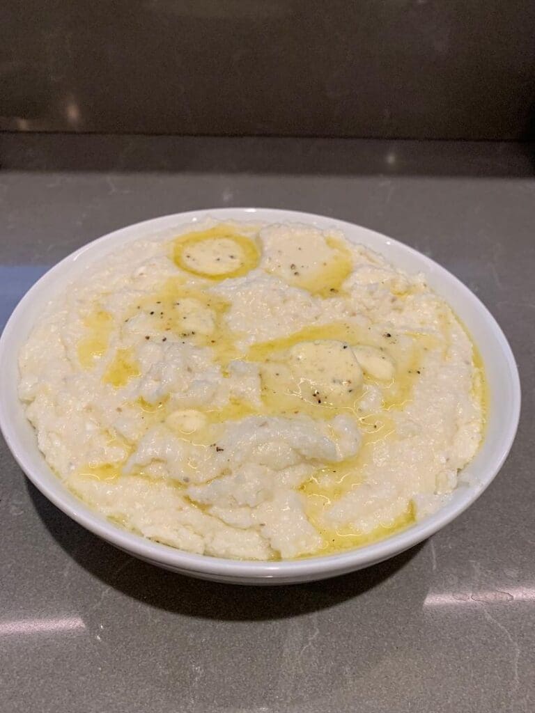 Bowl of creamy mashed potatoes with butter.