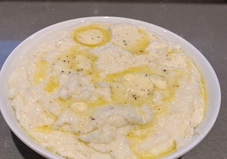 Bowl of creamy mashed potatoes with butter.